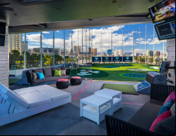 Each hitting bay at Topgolf features couches, an individual TV, charging stations and food and drink service. (photo by Topgolf Las Vegas)